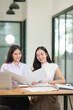 © junjira - Businessman, two Asian women give advice, discuss work, documents on laptop at office