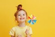 © Rufino - A young girl is holding a colorful paper fan and smiling