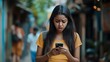 © Badass Prodigy - A young woman looks distressed while reading a message on her smartphone in a narrow street.