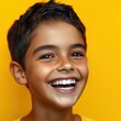 © Riya - Joyful young boy with bright smile against vibrant yellow background
