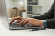 © New Africa - Businesswoman using laptop at white table indoors, closeup. Modern technology