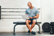 © peopleimages.com - Laptop, typing and manager with man in gym for fitness instructor, planning and digital membership record. Online schedule, personal trainer and equipment supervisor with person in health facility