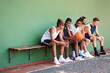 © peopleimages.com - Bench, basketball team or people relax on court for break, fitness exercise and wellness in sports match. Friends talking, athlete or group of healthy players resting for performance, workout or game