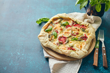 Wall Mural - Galette-type pie made from puff pastry and filled with tomatoes, mozzarella cheese and pesto sauce. Galette Caprese