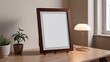 © Irina - Mockup,elegant empty photo frame displayed on a wooden table with a lamp and a plant