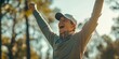 © Irina Ukrainets - A young golfer celebrating a victory outdoors in a sunlit forest. The excitement radiates as he raises his arms in triumph. Perfect for sports-themed projects and advertisements. AI