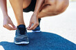 © Delmaine/peopleimages.com - Floor, tying laces and running with hands of person in road for start, performance and workout. Wellness, health and exercise with closeup of feet of runner for fitness, marathon athlete or training