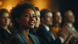 © Heidi - A diverse group of professionals seated and applauding in a conference setting, smiles on their faces. Warm lighting highlights their expressions.