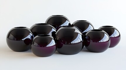 Wall Mural - A group of nine black, round, reflective vases of different sizes sit on a white surface.