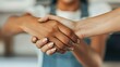 © ChimE - A confident businesswoman celebrates a successful trade agreement with a firm handshake, sealing a fruitful negotiation.