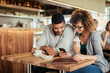 © Geber86 - Young couple using a smart phone in a cafe while enjoying a cup of coffee