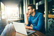 © peopleimages.com - Business man, laptop and phone call at cafe with talking, happy and remote work in morning. Person, writer and contact with networking, smartphone and smile with feedback for story at coffee shop