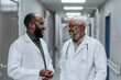 © Minerva Studio - Two male doctors in a brightly lit hospital corridor share a casual conversation, possibly discussing patient care or medical updates, displaying a strong sense of collaboration and commitment