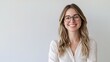 © WS Studio 1985 - Smiling and Confident Young Woman in Glasses Against a Simple Background, Perfect for Technology, Work, and Professional Themes