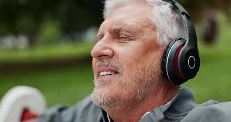 Canvas Print - Headphones, relax and senior man in park listening to audio, streaming music and radio outdoors. Entertainment, media subscription and happy mature person with track, podcast and playlist in nature