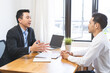 © KMPZZZ - Asian young manager, employer man interview with person, have question about resume and listen to candidate answer, conversation together at office. Recruitment employee job concept.
