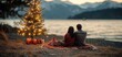 © kwangze - A couple enjoys a cozy evening by the lake with a decorated Christmas tree.