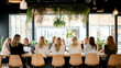 © VERTEX SPACE - A group of women engaged in collaborative meeting around large table, surrounded by greenery and natural light, creating vibrant and productive atmosphere
