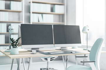 Wall Mural - Side view on blank dark modern computer monitors on light wooden table with light blue lamp, flowerpot and chair on white floor in sunny office with big window. 3D rendering, mockup