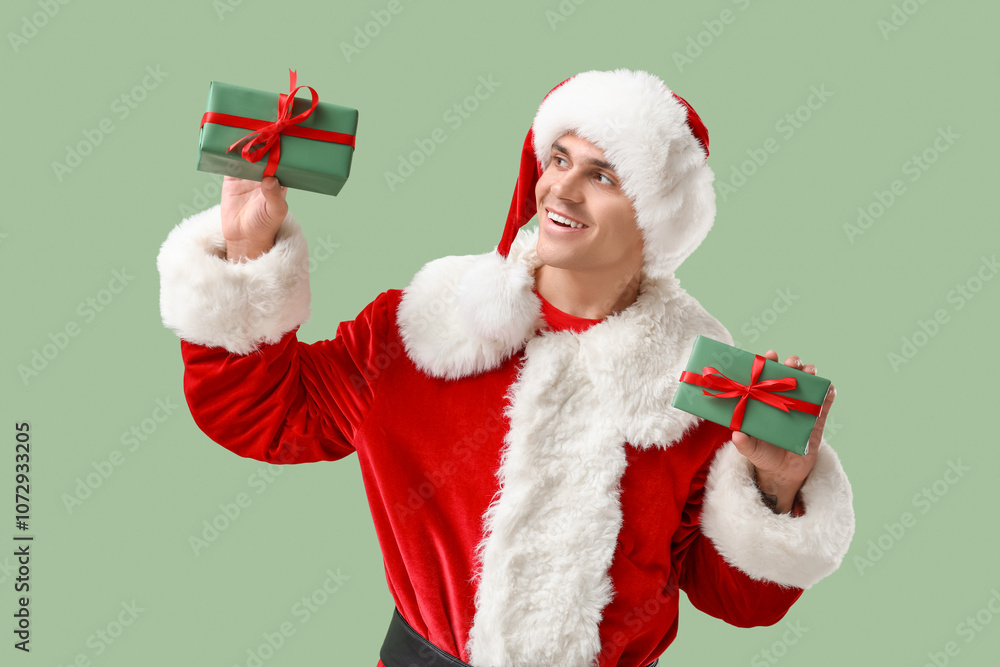 Santa Claus with gift boxes on green background