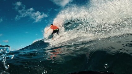 Wall Mural - Teen boy surfer rides the wave in the Maldives at sunset