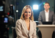 © Юлия Падина - Professional news anchors in a modern broadcast studio setting