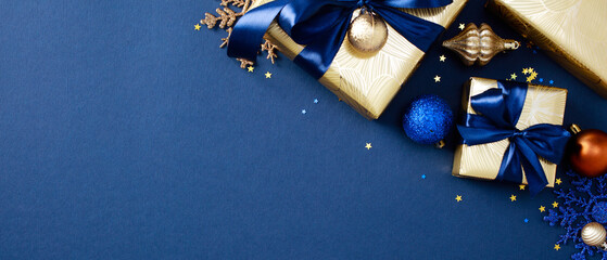 Wall Mural - Christmas banner design. Xmas Gifts wrapped in elegant gold paper with blue ribbons on dark blue background