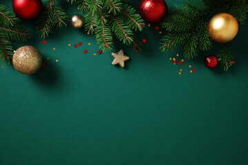 Wall Mural - Christmas background with pine branches, colorful baubles, and glitter stars on dark green. Flat lay, top view, copy space