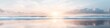 © Chaikit - majestic beach sunrise, gentle wave patterns, pastel colored clouds, reflective wet sand, peaceful ocean view, morning sunburst, smooth water motion, cinematic coastal photography, ethereal lighting