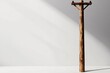 © kwangze - A rustic wooden utility pole casting shadows in a minimalist space.