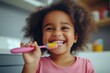 © kazakova0684 - A child smiling at the dentist after receiving a fun, colorful toothbrush at the end of a dental appointment
