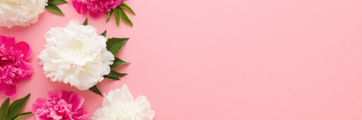 Wall Mural - Fresh beautiful soft white pink peony flowers with green leaves on pink table background. Pastel color. Closeup. Empty place for inspirational text, quote or sayings. Wide banner. Top down view.