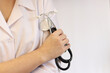 © Mariia - Doctor or nurse with stethoscope in hand. Medicine and health concept. Pediatrician in white coat with stethoscope. Woman, medical and cardiac monitoring instrument, white background. Copy space