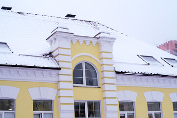 Wall Mural - An old building with stucco on the facade, covered in snow