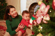 © MrPanya - Mother and son playing together on Christmas Eve. Happy family. Mother and little son. Christmas tree. Family holiday.