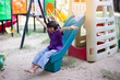 © chaunpis - Joyful Children Sliding Down A Playground Slide During A Sunny Afternoon