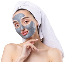 A woman with a gray clay cosmetic mask in a white towel on her head on a white background.