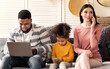 © Prostock-studio - Millennial international family with devices. Dad with laptop, daughter plays on smartphone, mom speaks on phone at home during quarantine
