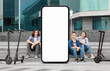 © Prostock-studio - Three young adults are seated on steps near electric scooters and huge phone with blank screen in a modern urban environment. They are smiling and relaxed, embodying a carefree lifestyle