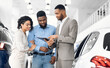 © Prostock-studio - Car Sales. Afro Spouses Buying Auto Consulting With Dealer Guy Standing In Luxury Dealership Store.