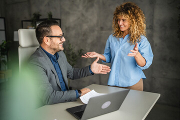 Wall Mural - female colleague bring to male colleague document for signature