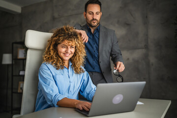 Wall Mural - colleagues work together on laptop and from information from envelope