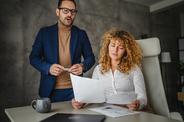 male colleague give advice and help female colleague to finish work