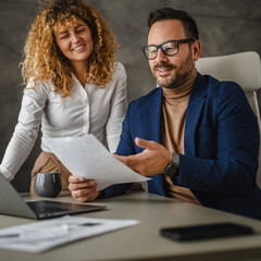 Wall Mural - two colleagues work together and review contract in the office