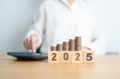 © Jo Panuwat D - Happy New Year 2025 with Coins stack and calculator. Money, Budget, tax, investment, financial, savings and New Year Resolution concepts