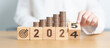 © Jo Panuwat D - 2024 end year to Happy New Year 2025 with Coins stack and dartboard icon. Strategy, goal, Money, Budget, tax, investment, financial, savings and New Year Resolution concepts