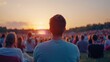 © Prim2513 - A serene sunset view at a crowded outdoor event, highlighting an individual observing the scene, surrounded by an audience.