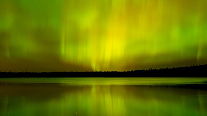 Wall Mural - bright green to yellow and orange aurora northern lights over calm northern lake