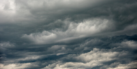 Wall Mural - panorama dramatic storm rain clouds with shades of light to dark grey and blue
