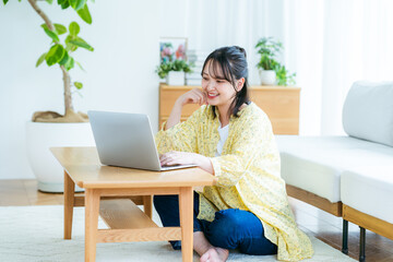 自宅でノートパソコンを操作する若い女性